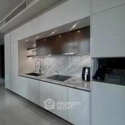 Sleek modern kitchen with marble backsplash and integrated appliances