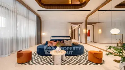 Luxurious living room with modern design, featuring a plush blue sofa, stylish chairs, and elegant decor.