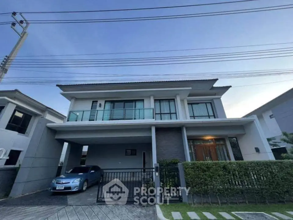 Modern two-story house with spacious driveway and sleek design in a suburban neighborhood.