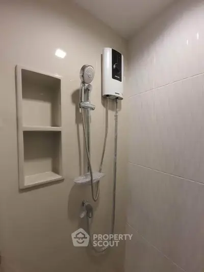 Modern bathroom with sleek showerhead and built-in shelving, perfect for a minimalist design.
