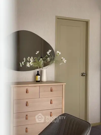 Stylish bedroom corner with modern dresser and decorative mirror