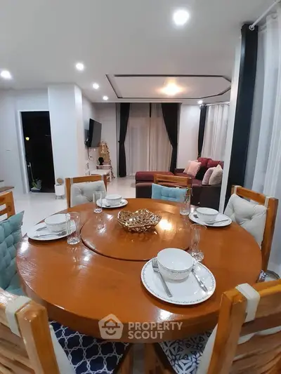 Elegant dining area with wooden table and cozy seating in modern living room.