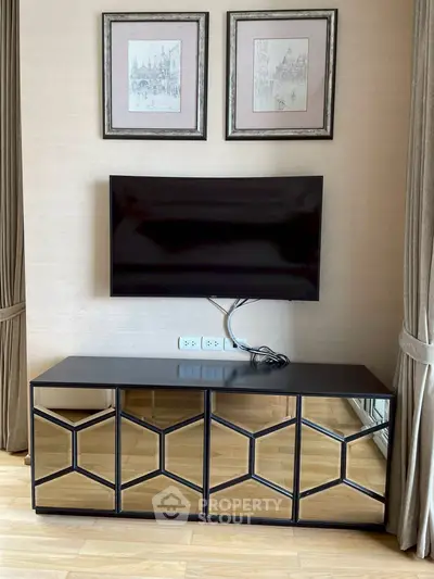Stylish living room with modern TV setup and elegant mirrored console table.