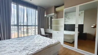 Bright bedroom with large window, mirrored wardrobe, and modern decor in urban apartment.