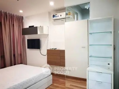 Modern bedroom with sleek design, featuring built-in shelves and air conditioning.