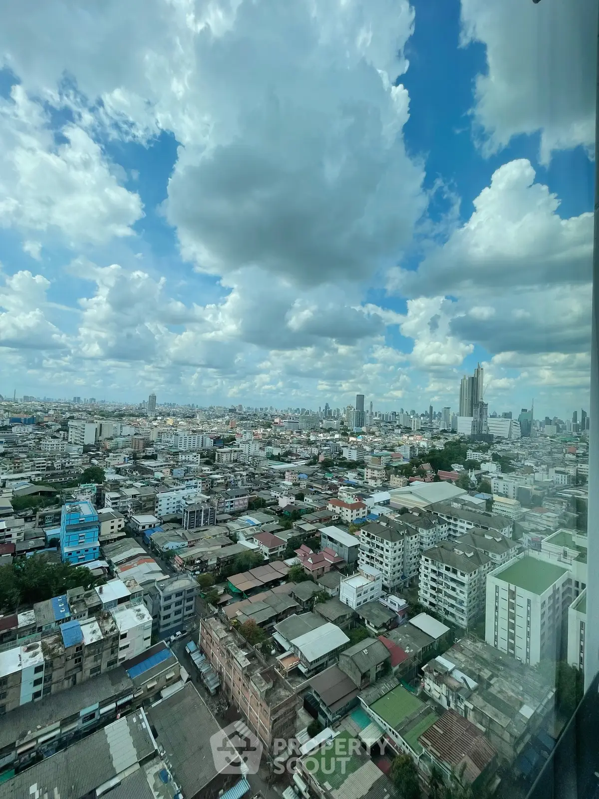 Stunning cityscape view from high-rise building showcasing urban skyline and vibrant clouds.