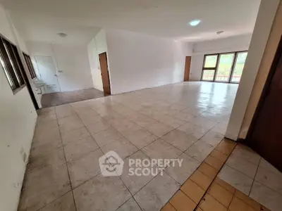 Spacious open-plan living area with large windows and tiled flooring, ideal for customization.