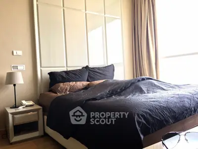 Luxurious bedroom with elegant decor and large window offering natural light.