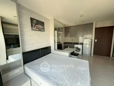 Modern studio apartment with integrated kitchen and washing machine, featuring sleek design and ample natural light.