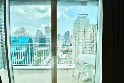 Stunning city view from a high-rise balcony with modern outdoor seating.