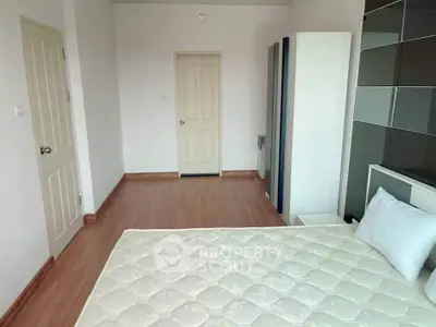 Spacious bedroom with minimalist design and wooden flooring