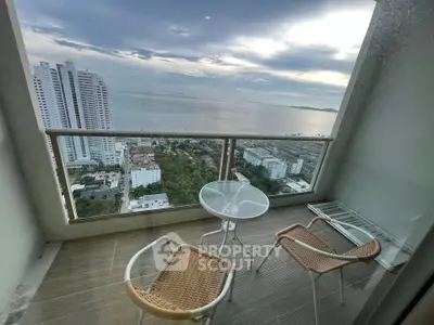 Stunning high-rise balcony with ocean view and modern outdoor seating.