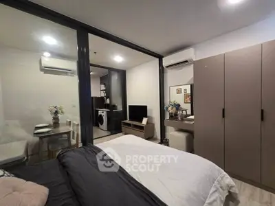 Modern bedroom with glass partition, cozy decor, and adjacent dining area in stylish apartment.
