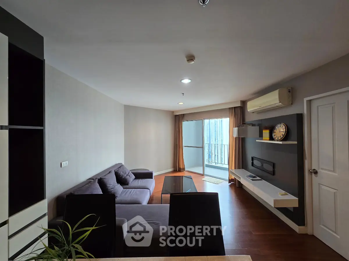 Spacious living room with modern furniture and balcony view in a stylish apartment.