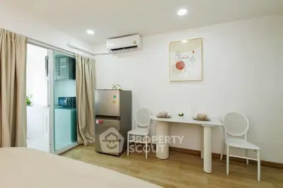 Modern studio apartment with compact dining area and sleek appliances.