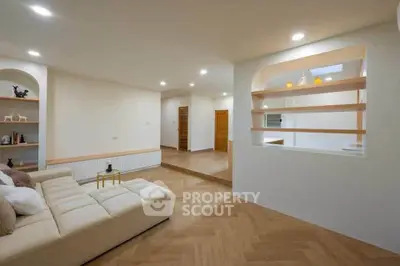 Spacious modern living room with elegant wooden flooring and cozy seating area.
