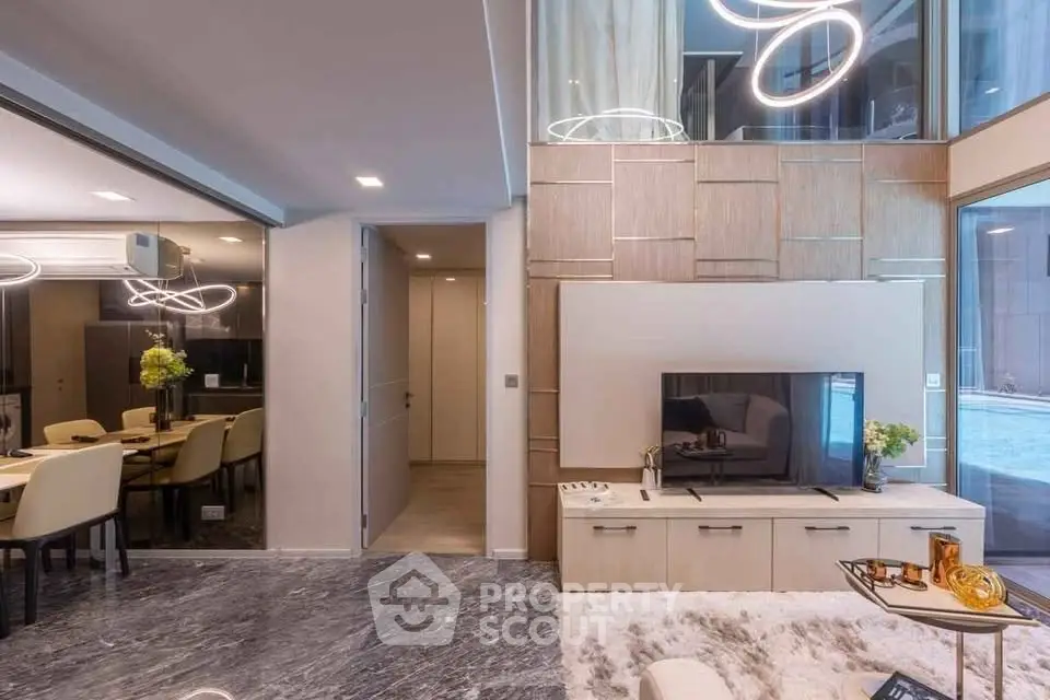 Luxurious modern living room with elegant decor and open dining area, featuring stylish lighting and a cozy ambiance.