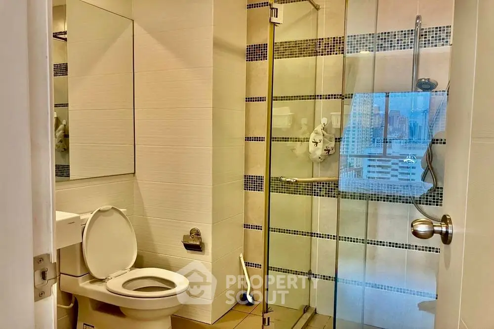 Modern bathroom with glass shower and city view window