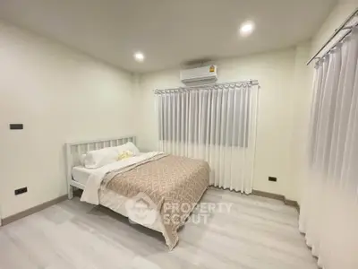 Cozy bedroom with modern decor and air conditioning, perfect for relaxation.