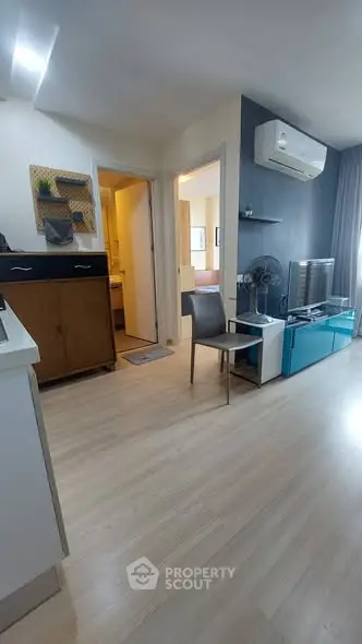 Modern living room with sleek design and air conditioning, featuring light wood flooring and stylish furniture.