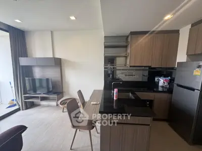 Modern open-layout kitchen and living area with sleek wooden cabinets and contemporary furniture.