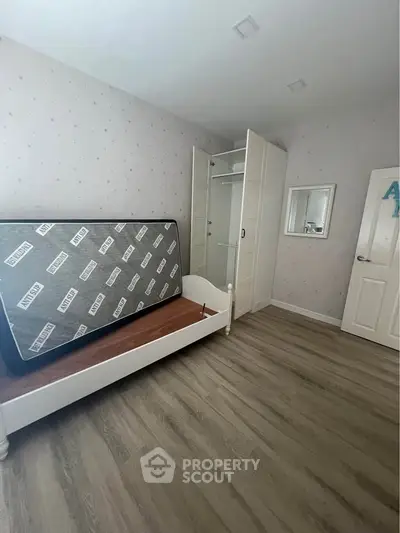 Spacious bedroom with wooden flooring and built-in wardrobe, perfect for modern living.