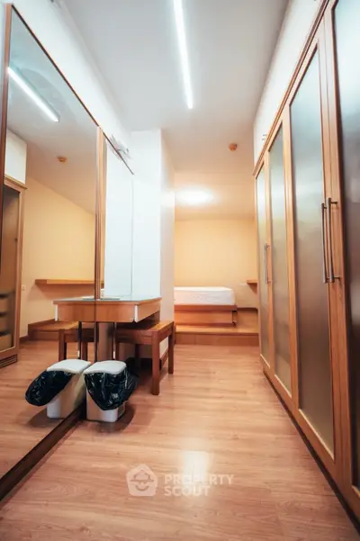 Spacious bedroom with wooden flooring and ample closet space