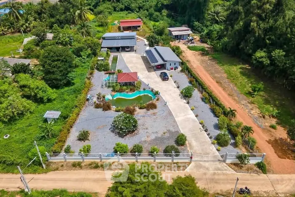 Aerial view of a spacious property with a pool and lush greenery, ideal for serene living.