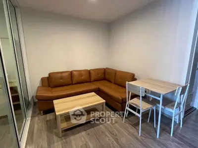 Cozy living room with brown leather sofa and wooden dining set, perfect for modern living.