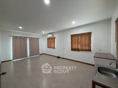 Spacious unfurnished room with tiled flooring, air conditioning, and natural light from large windows.