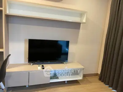 Modern living room with sleek TV stand and flat-screen TV, perfect for entertainment.