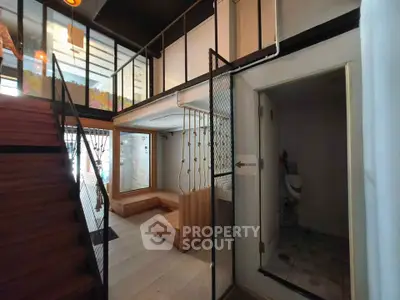 Modern interior with stylish staircase and cozy seating area, perfect for urban living.