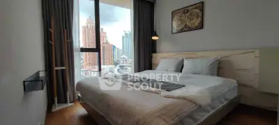 Modern bedroom with city view, stylish decor, and large window for natural light.