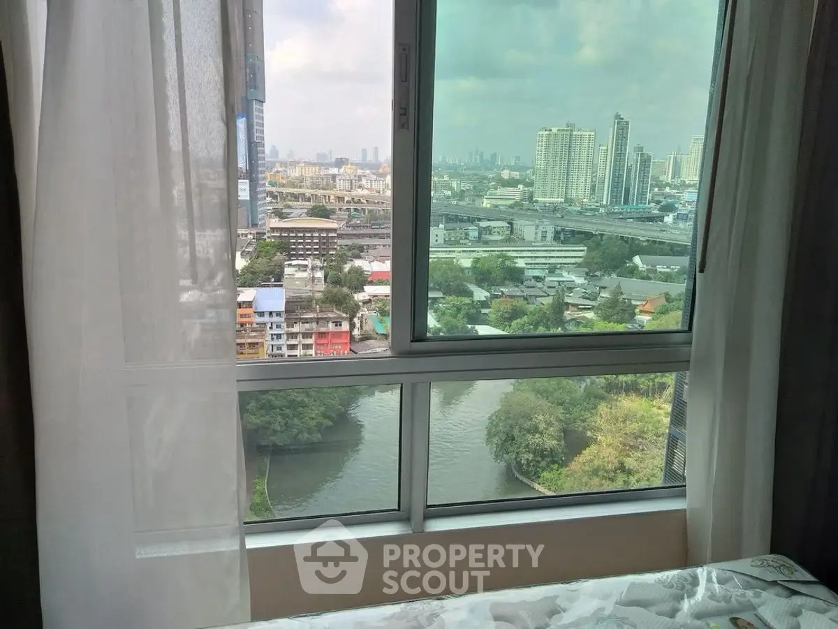 Stunning cityscape view from a high-rise apartment window, showcasing urban skyline and river.