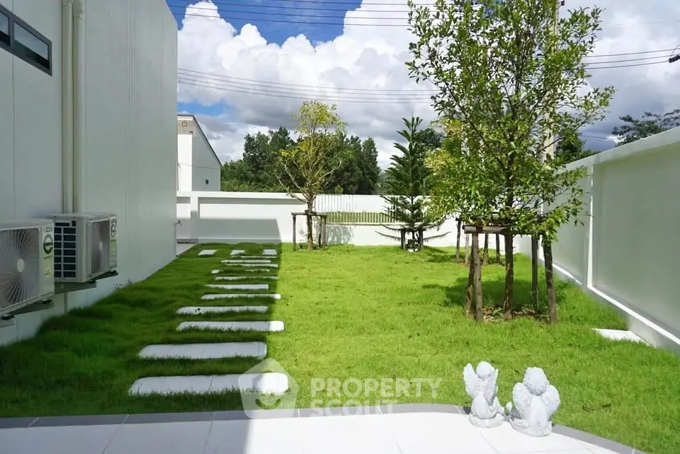 Spacious garden with lush greenery and decorative statues in modern property