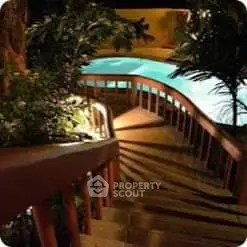Charming outdoor pool area with wooden staircase and lush greenery