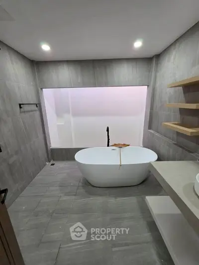 Luxurious modern bathroom with freestanding bathtub and elegant shelving.