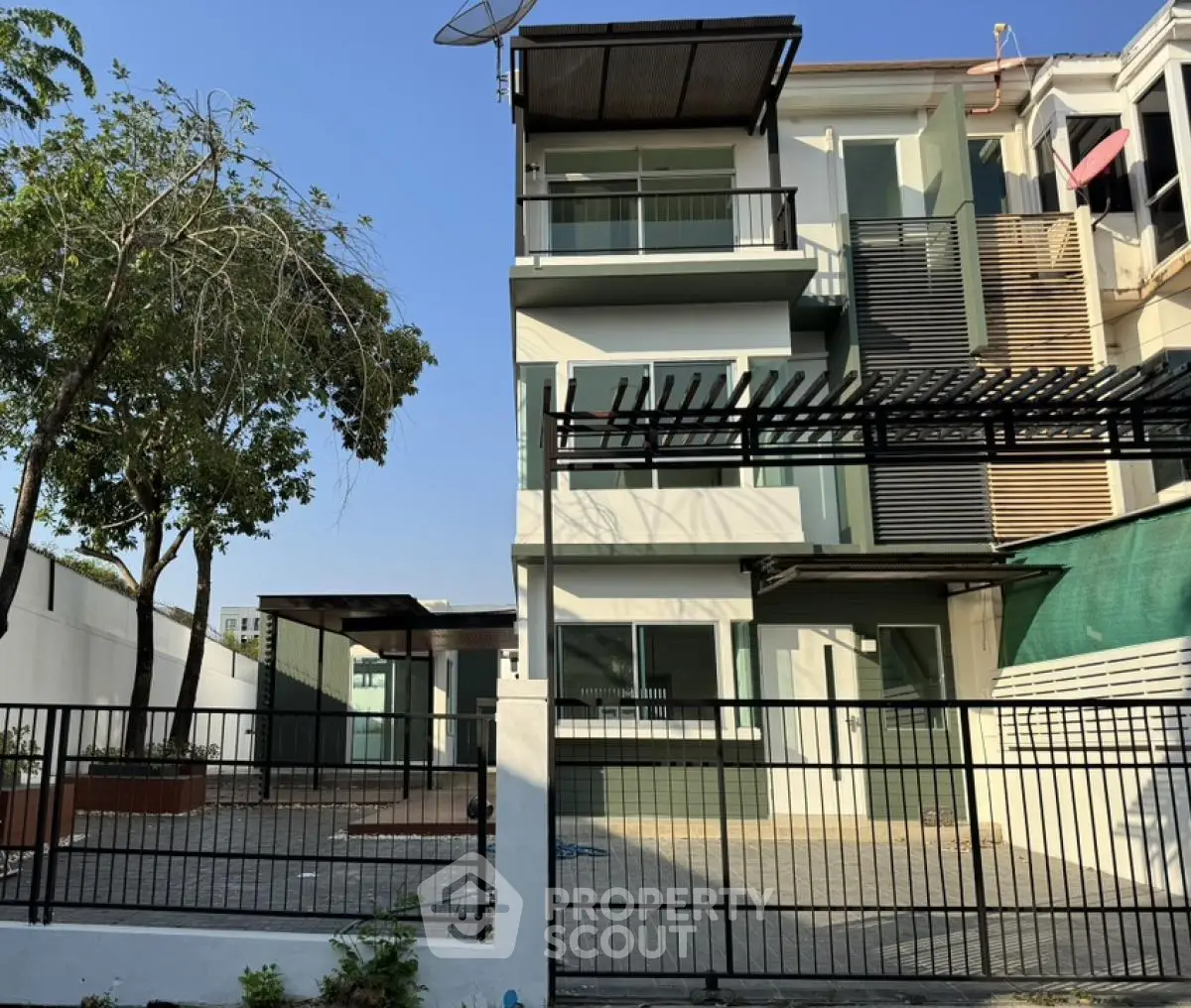 Modern three-story townhouse with spacious balcony and gated entrance in a serene neighborhood.