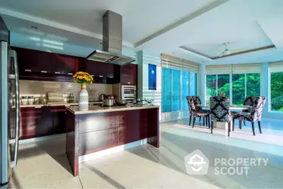 Luxurious open-layout kitchen with modern appliances and dining area overlooking lush greenery.