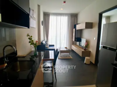 Modern living room with sleek kitchen, stylish furniture, and large window for natural light.