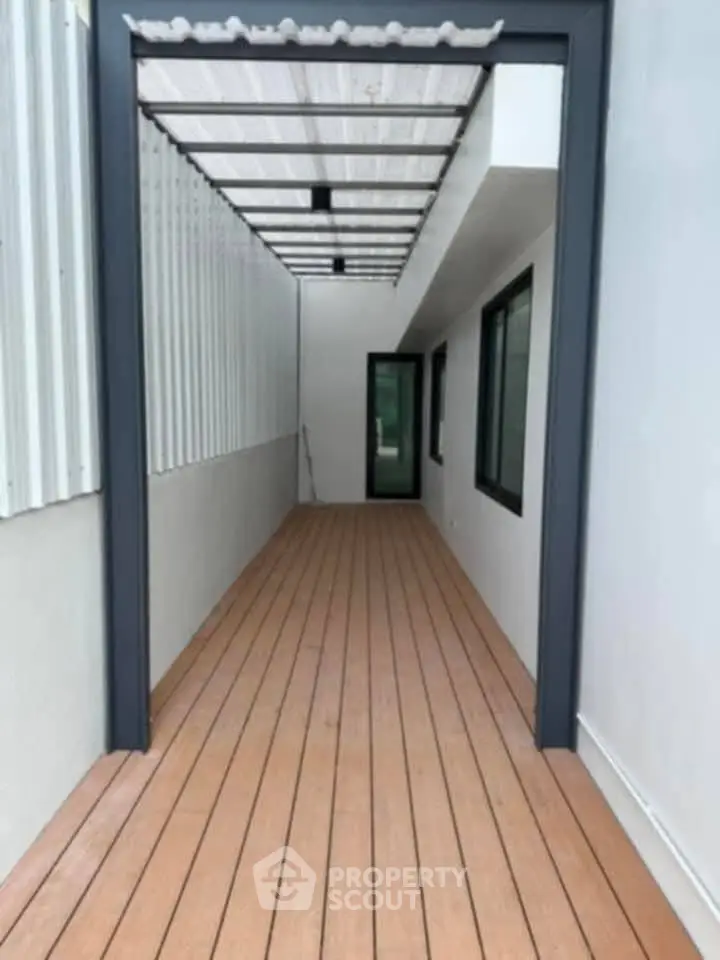 Modern balcony with wooden flooring and sleek design, perfect for relaxation.