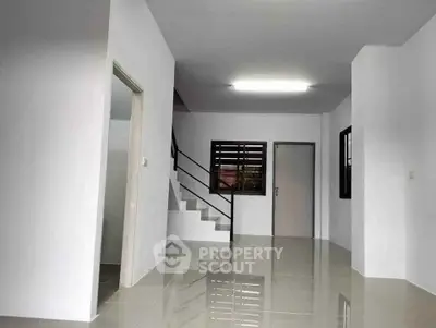 Spacious modern interior with sleek staircase and glossy tiled floors, perfect for contemporary living.