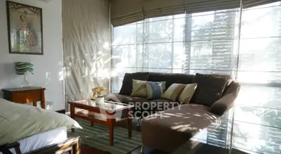 Bright and cozy living room with sectional sofa and large windows