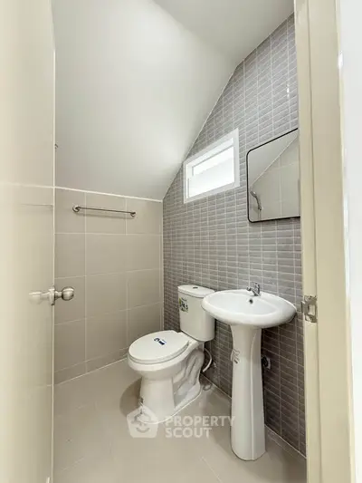 Compact modern bathroom with sleek fixtures and neutral tiles