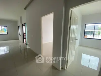 Spacious modern interior with glossy tiled floors and ample natural light, showcasing open layout and large windows.
