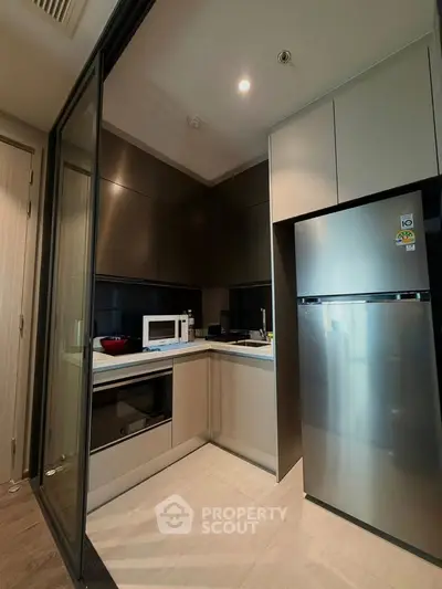 Modern kitchen with sleek appliances and closed layout in a stylish apartment.