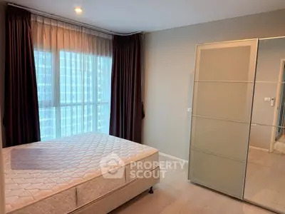 Modern bedroom with large window and sliding wardrobe in a stylish apartment.