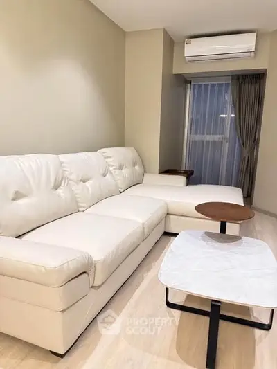 Modern living room with white sectional sofa and air conditioning