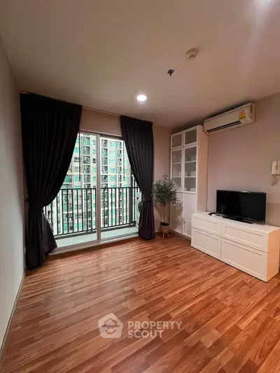 Spacious living room with wooden flooring and balcony view in modern apartment.