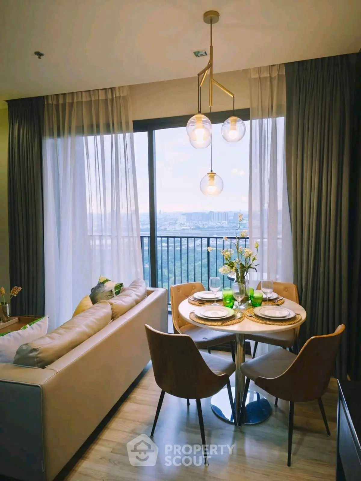 Chic living room with dining area and stunning city view from balcony.